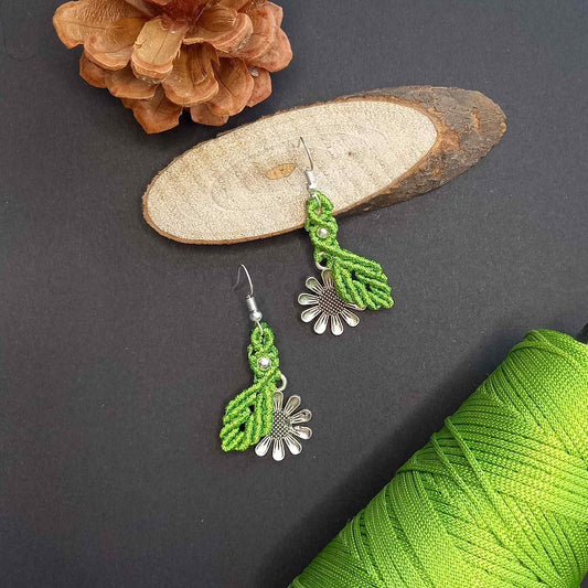 macrame dangler earrings featuring a single leaf over a silver daisy charm