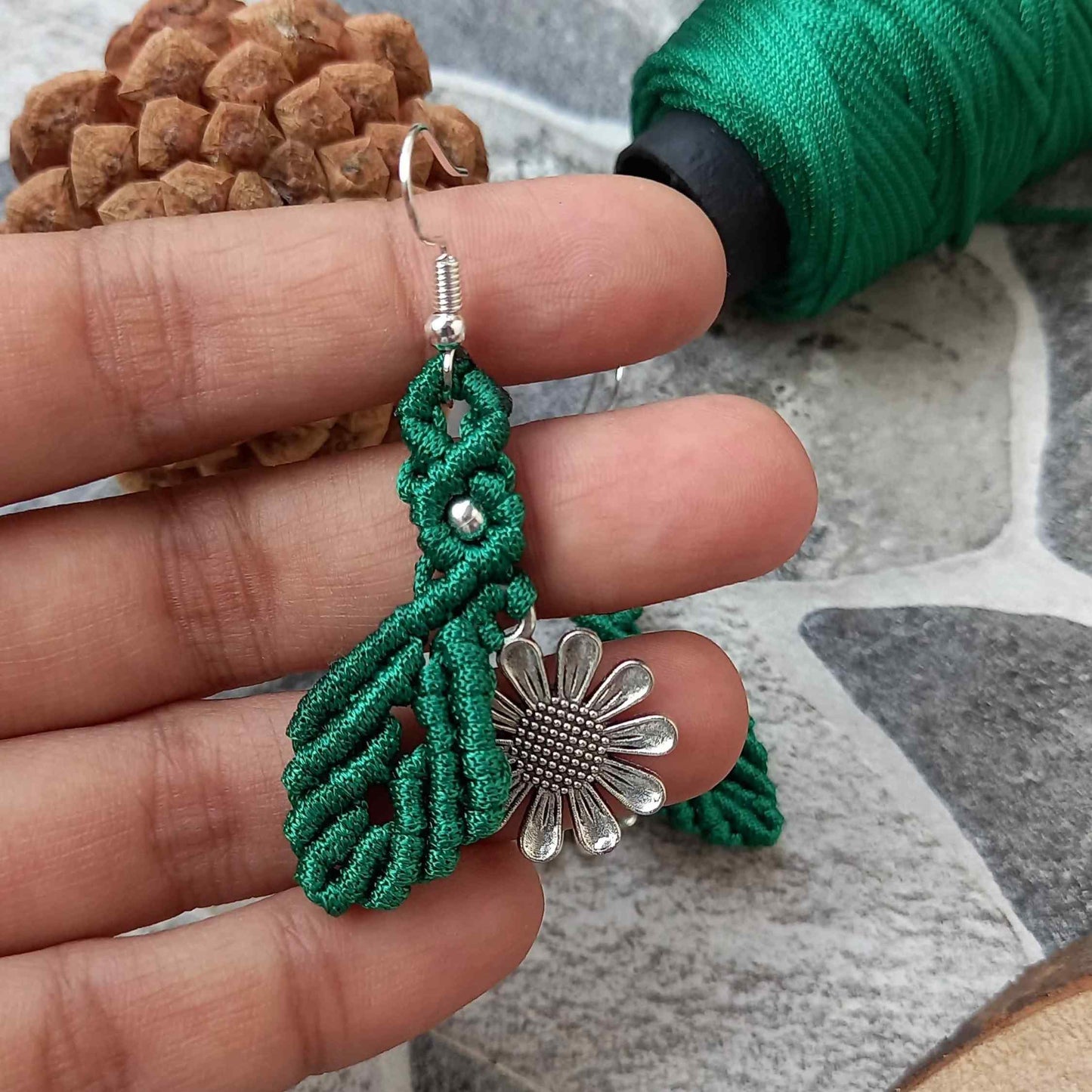 macrame dangler earrings featuring a single leaf over a silver daisy charm