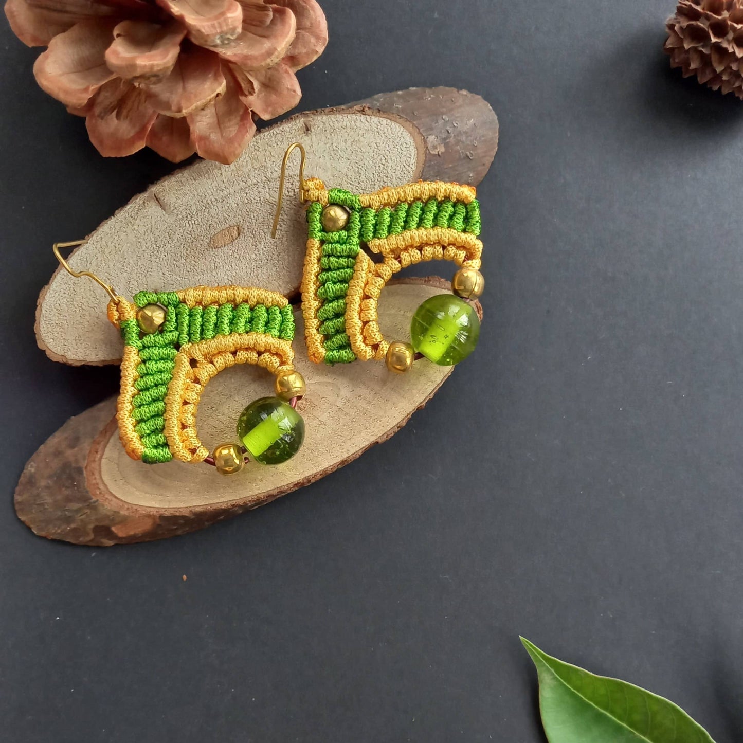 macrame dangler earrings in two colours with a large ceramic focal bead