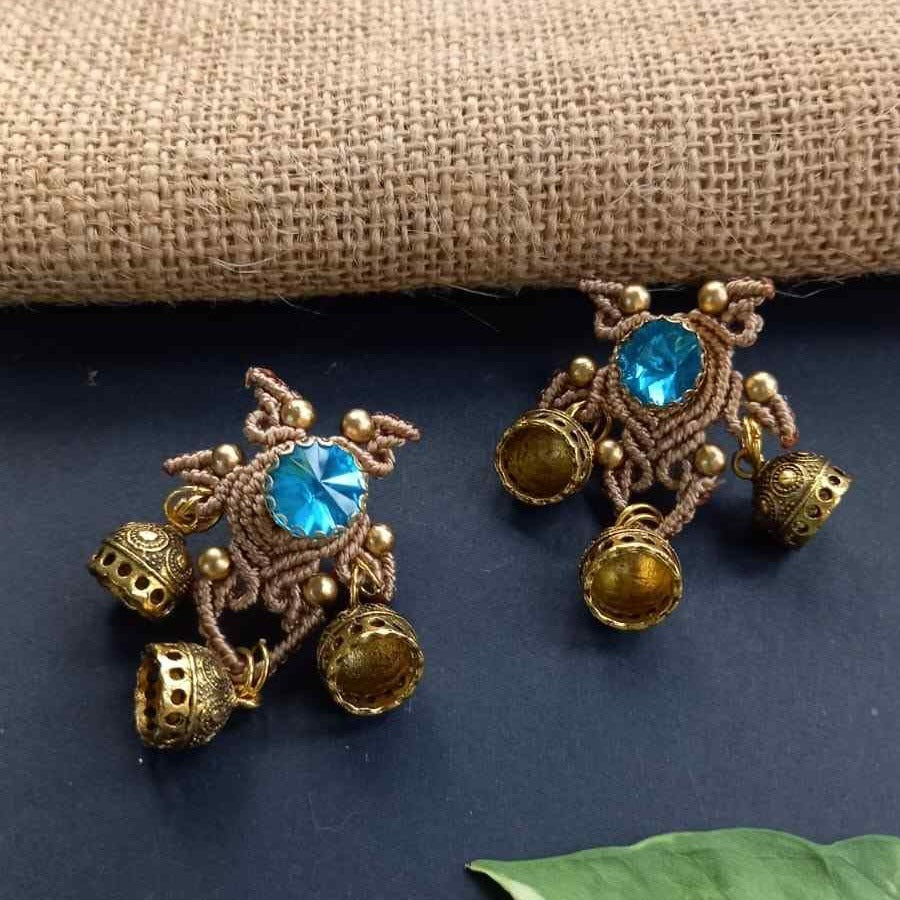 unusual stud earrings with macrame work around a blue rhinestone and three jhumkis