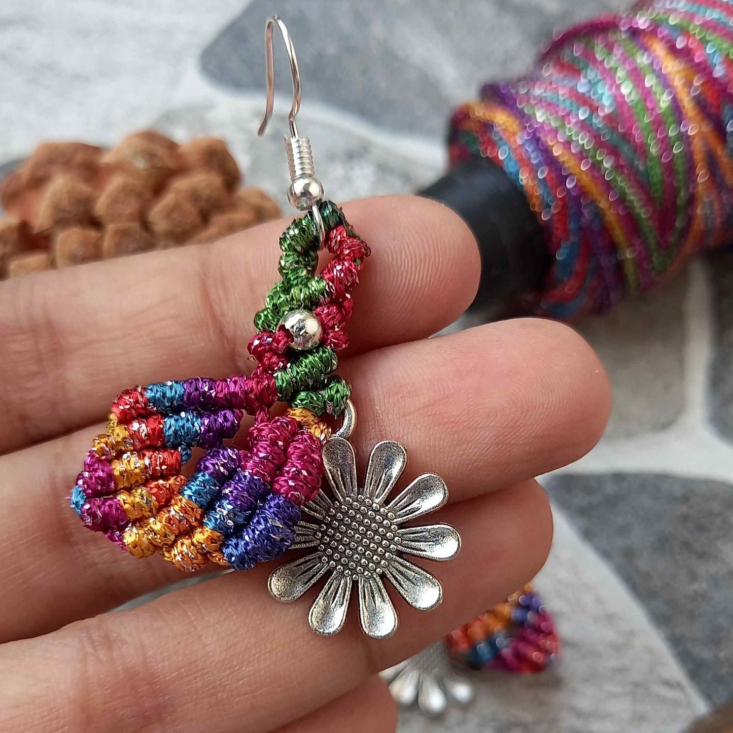macrame dangler earrings featuring a single leaf over a silver daisy charm
