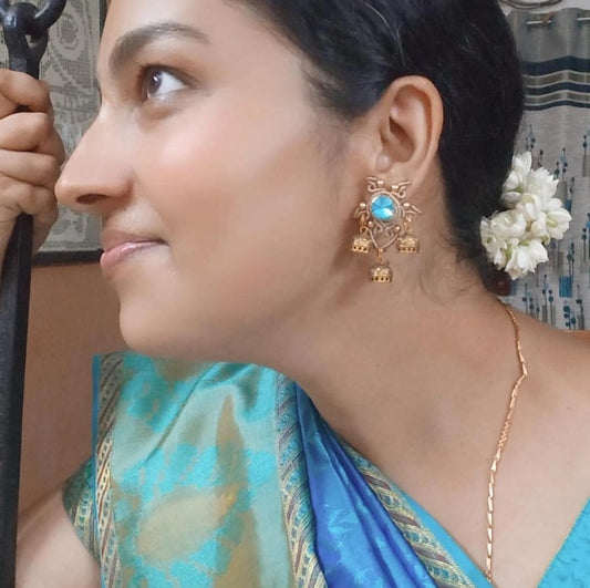 unusual stud earrings with macrame work around a blue rhinestone and three jhumkis