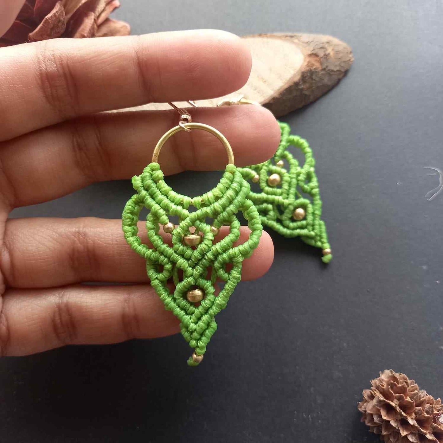 light green handmade macrame earrings with a lace like design and brass beads