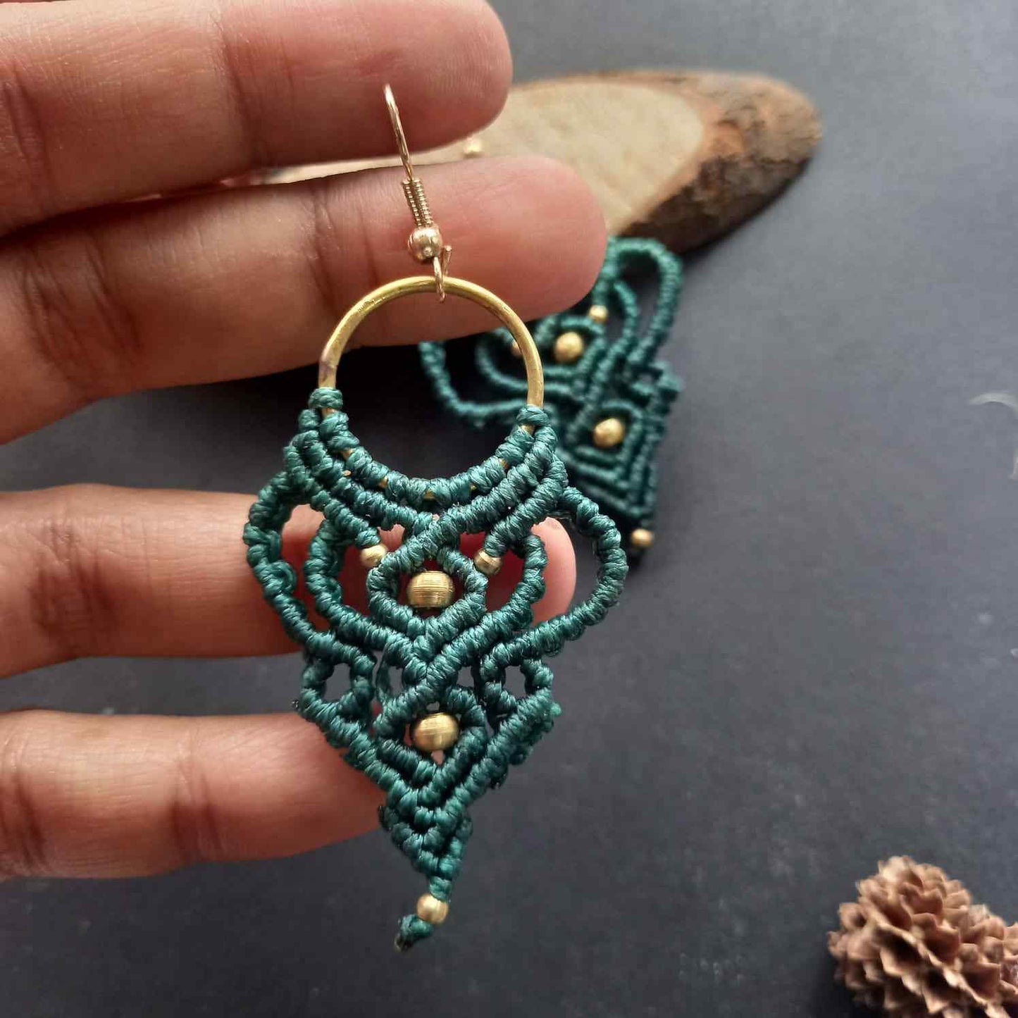 dark green handmade macrame earrings with a lace like design and brass beads