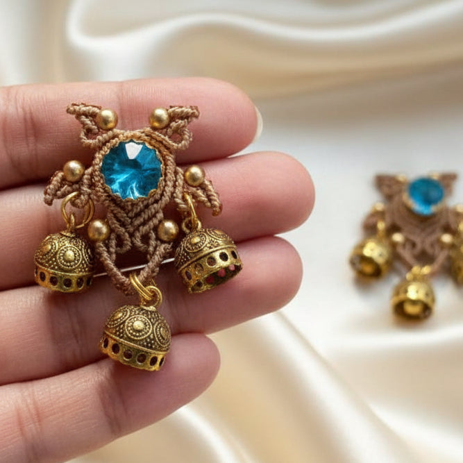 unusual stud earrings with macrame work around a blue rhinestone and three jhumkis