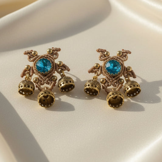 unusual stud earrings with macrame work around a blue rhinestone and three jhumkis