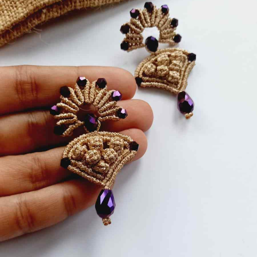 beige macrame pendant earrings set with faceted metallic purple beads