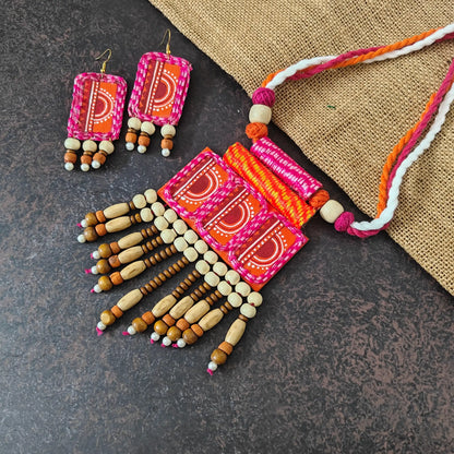 Aruna fabric necklace set — pendant of repeating rectangular fabric motifs joined to resemble a macrame wall hanging, with a wooden bead tassel