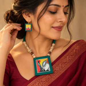 Kalavati green fabric necklace set — green cotton pendant hand-painted with a woman's face wearing kumkum and flowers, with matching dangler earrings