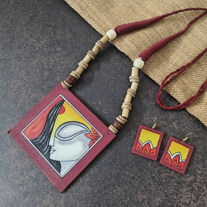 Kalavati maroon fabric necklace set — maroon cotton pendant hand-painted with a woman's face wearing kumkum and flowers, with matching dangler earrings