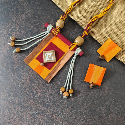 Mrinmayi orange fabric necklace set — rectangular orange ikkat pendant with a maroon applique and hand-painted terracotta motif, with stud dangler earrings