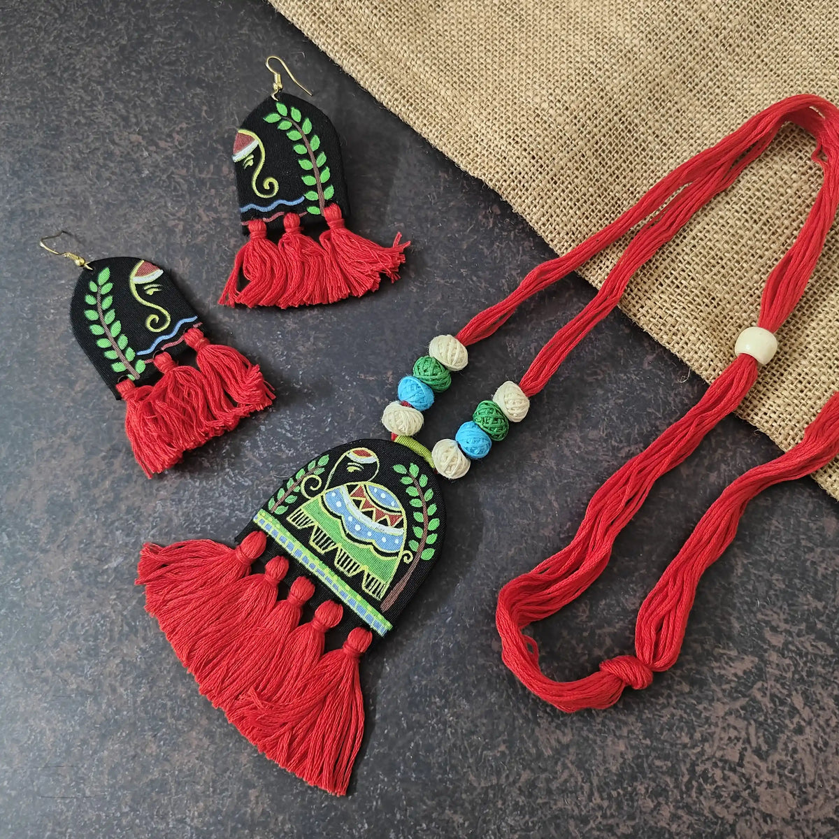 Rangini red fabric necklace set — semicircular pendant with a hand-painted elephant and red cotton thread tassels, with matching semicircular earrings