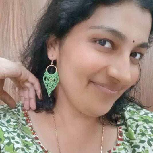 light green handmade macrame earrings with a lace like design and brass beads