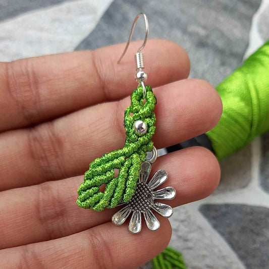 macrame dangler earrings featuring a single leaf over a silver daisy charm