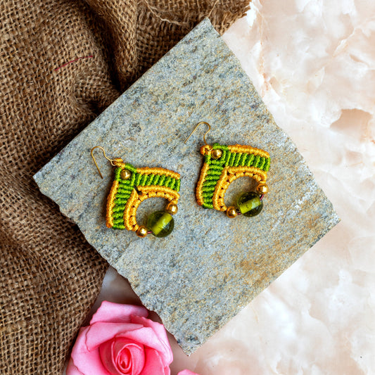 macrame dangler earrings in two colours with a large ceramic focal bead