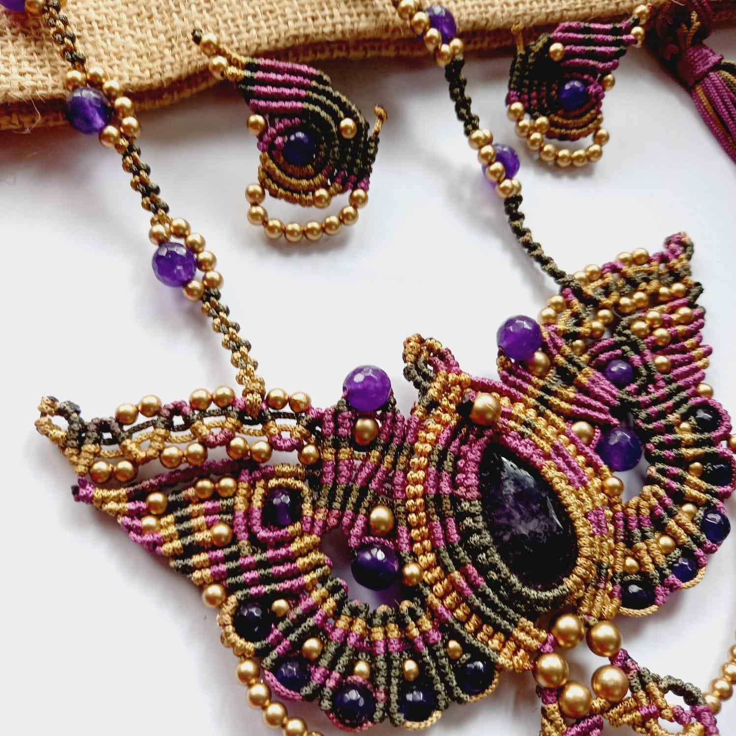 macrame pendant earrings set in the shape of a butterfly featuring amethyst stones and agate beads