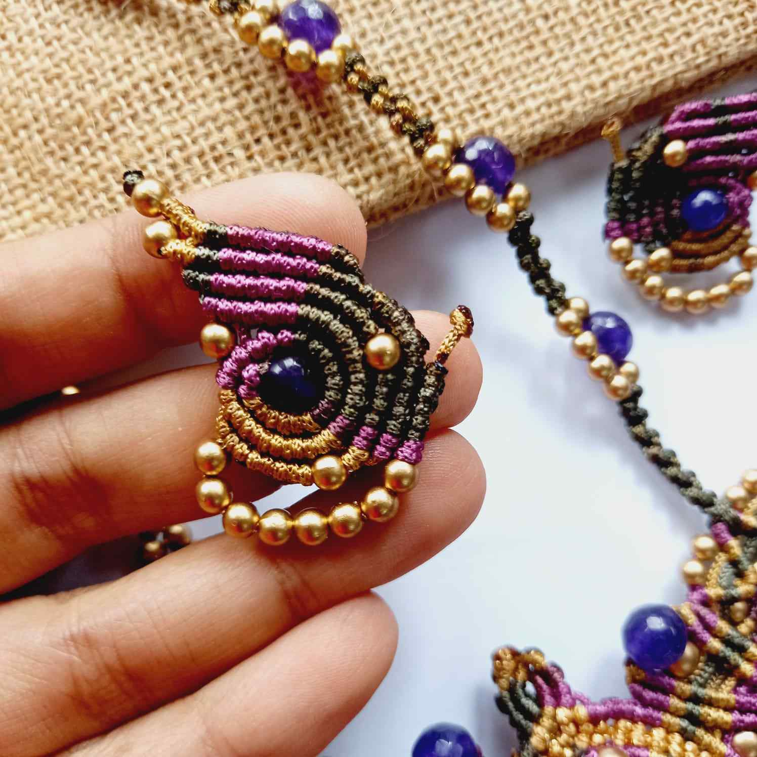 macrame pendant earrings set in the shape of a butterfly featuring amethyst stones and agate beads