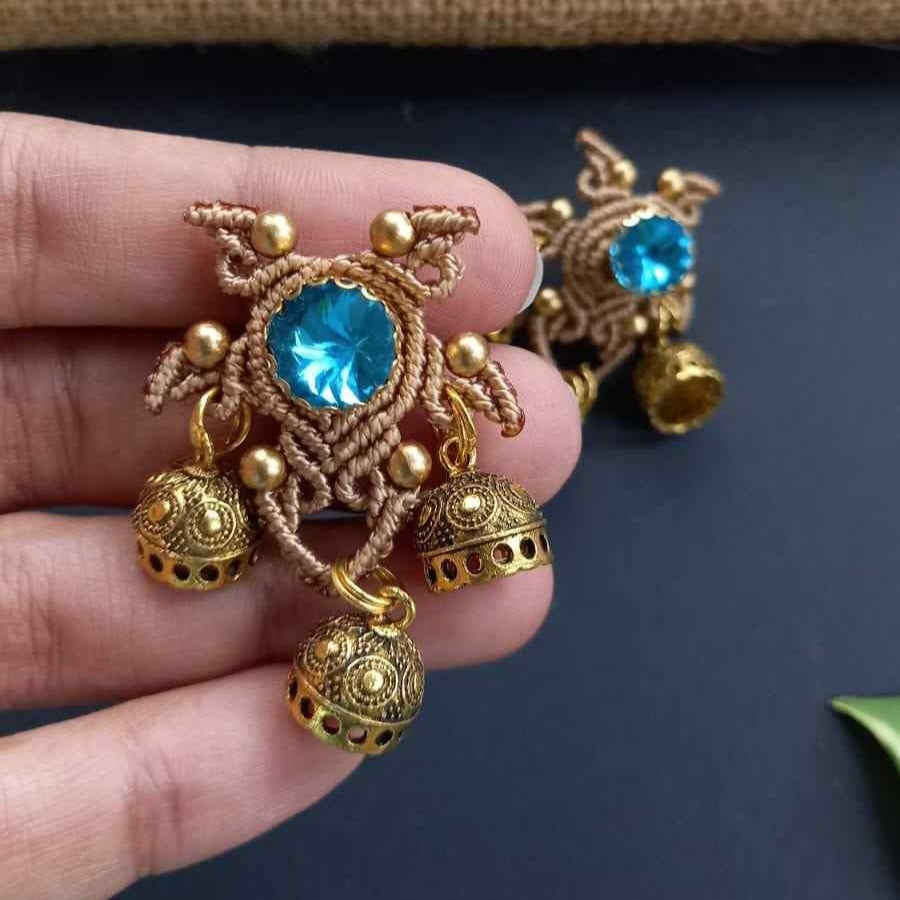 unusual stud earrings with macrame work around a blue rhinestone and three jhumkis