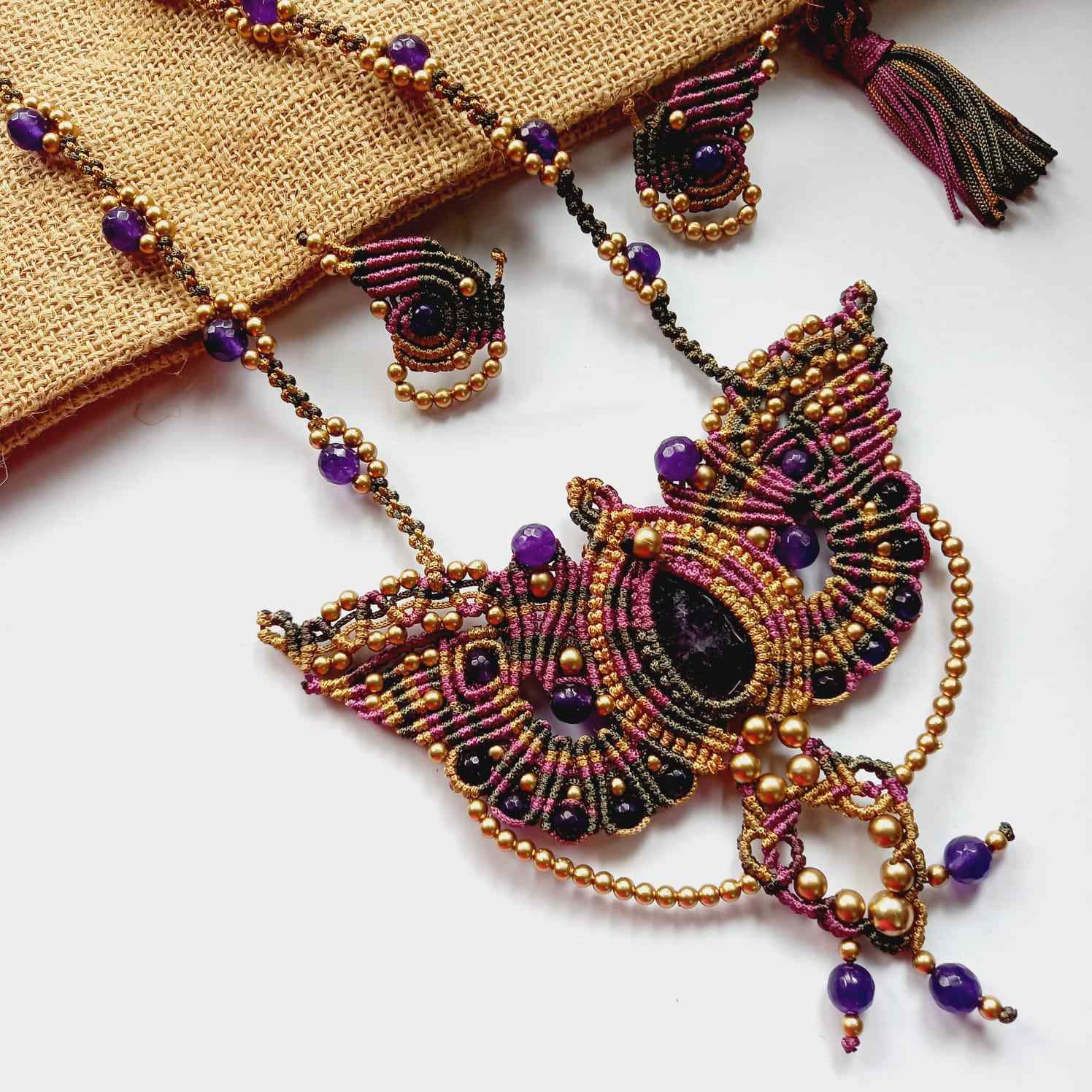 macrame pendant earrings set in the shape of a butterfly featuring amethyst stones and agate beads