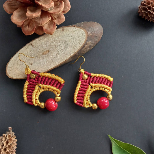 macrame dangler earrings in two colours with a large ceramic focal bead