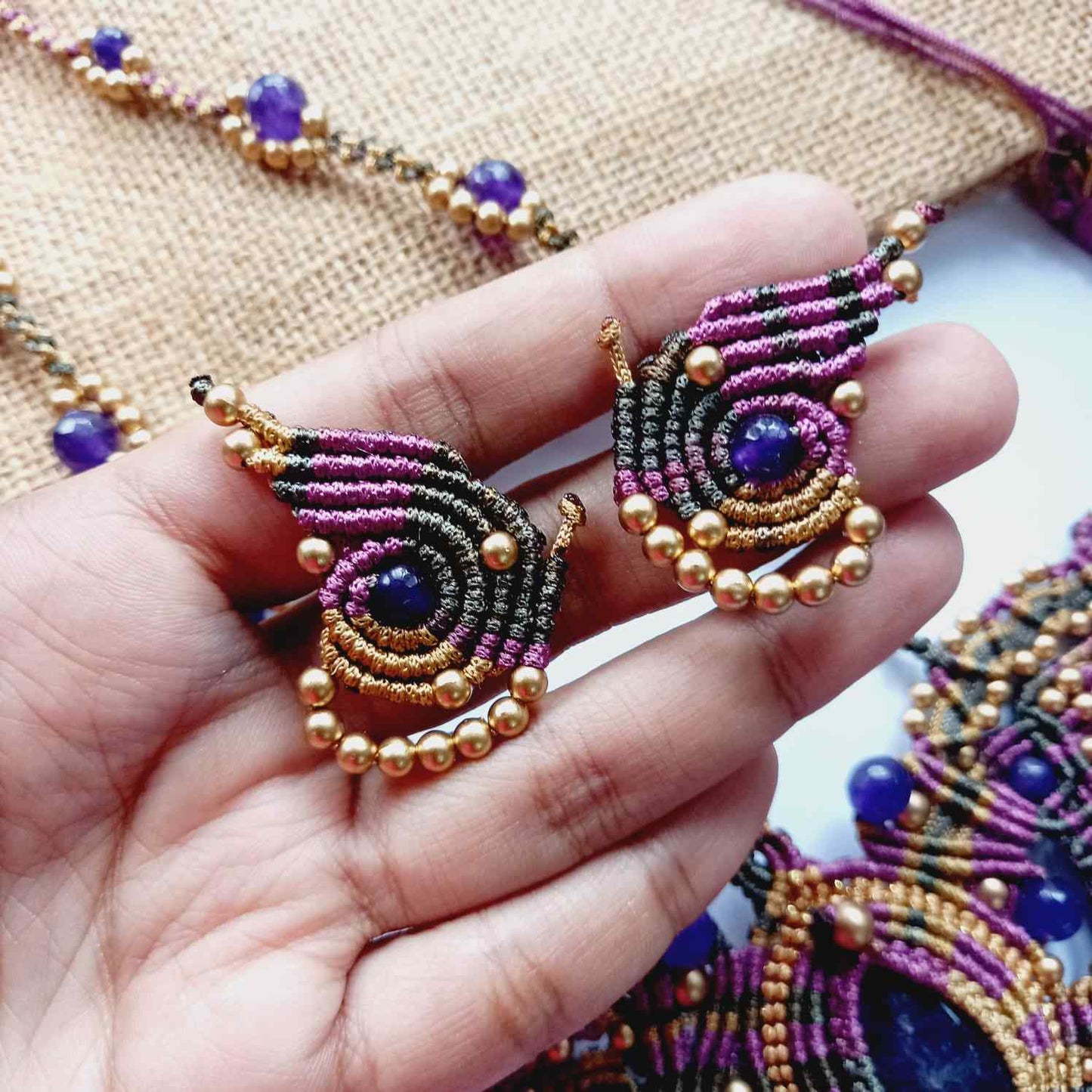 macrame pendant earrings set in the shape of a butterfly featuring amethyst stones and agate beads